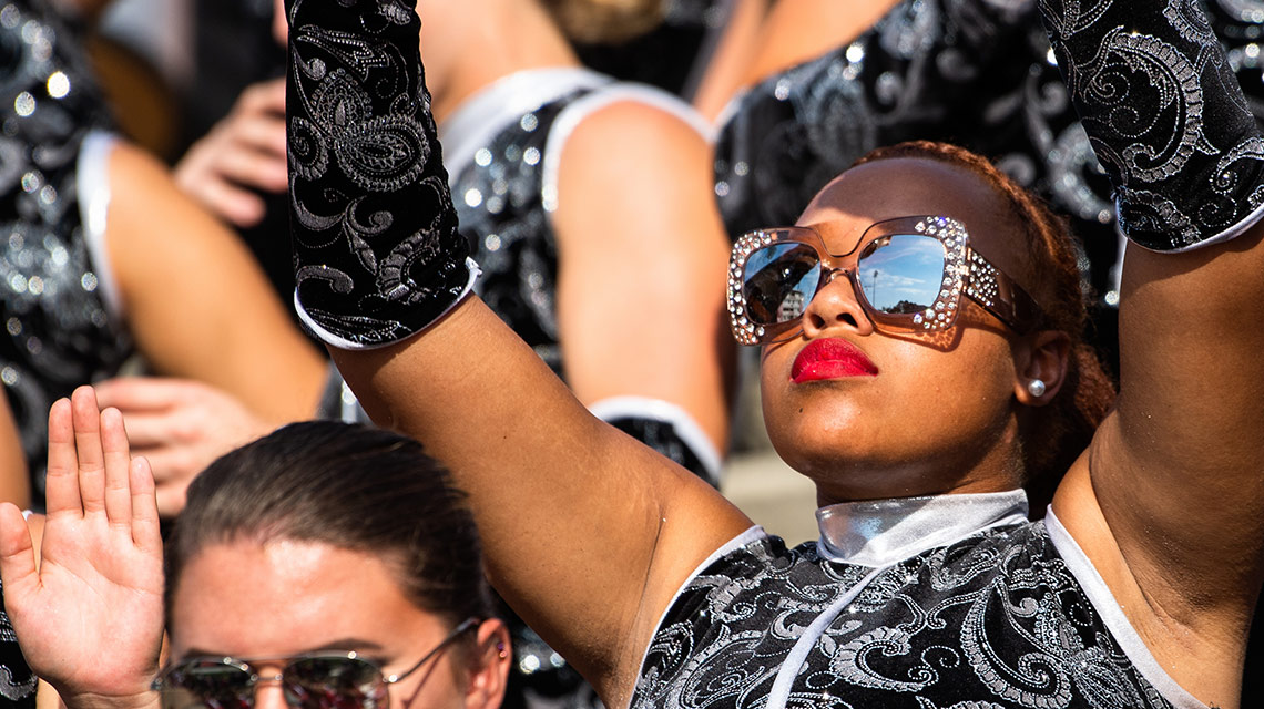 A Southerners color guard member sports bedazzled sunglasses in the stands during the homecoming game