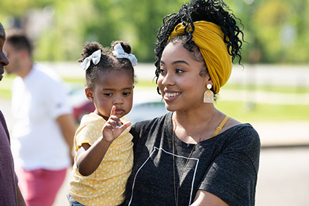 A student with her child outside at a JSU event