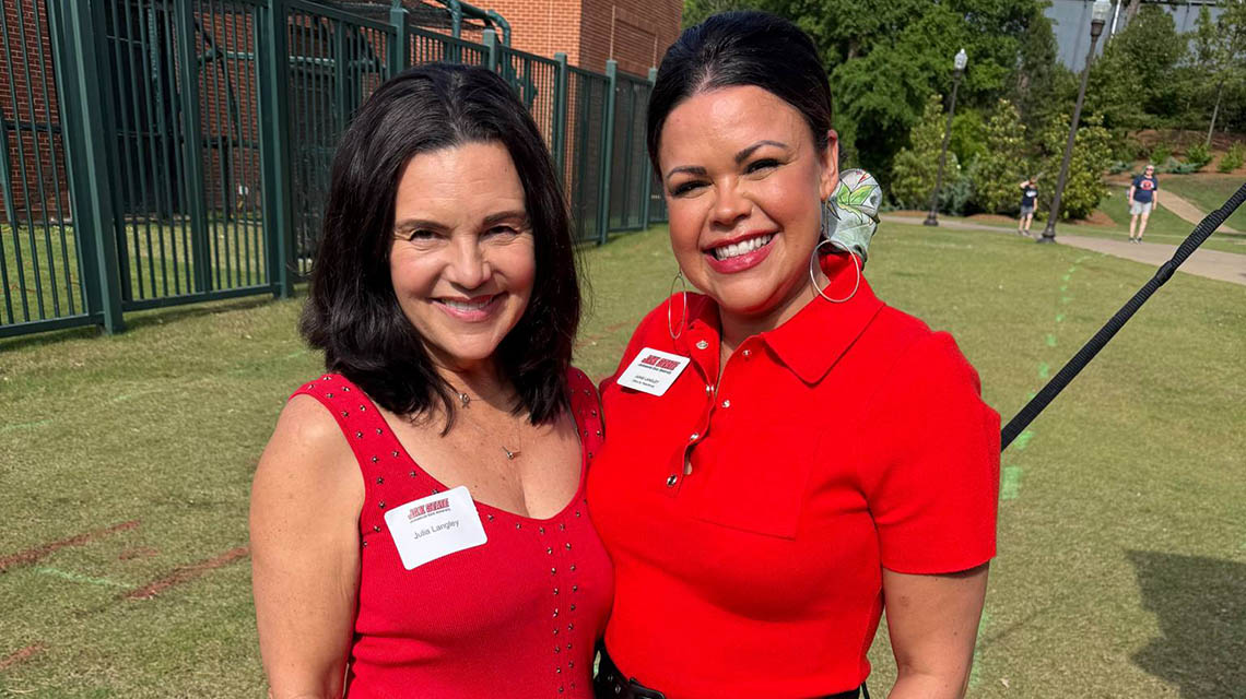 two proud alum smile for a photo