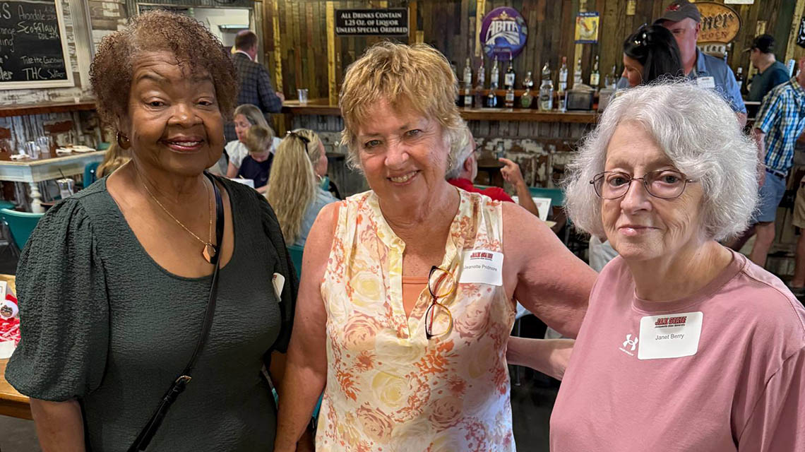alumni friends pose for a photo