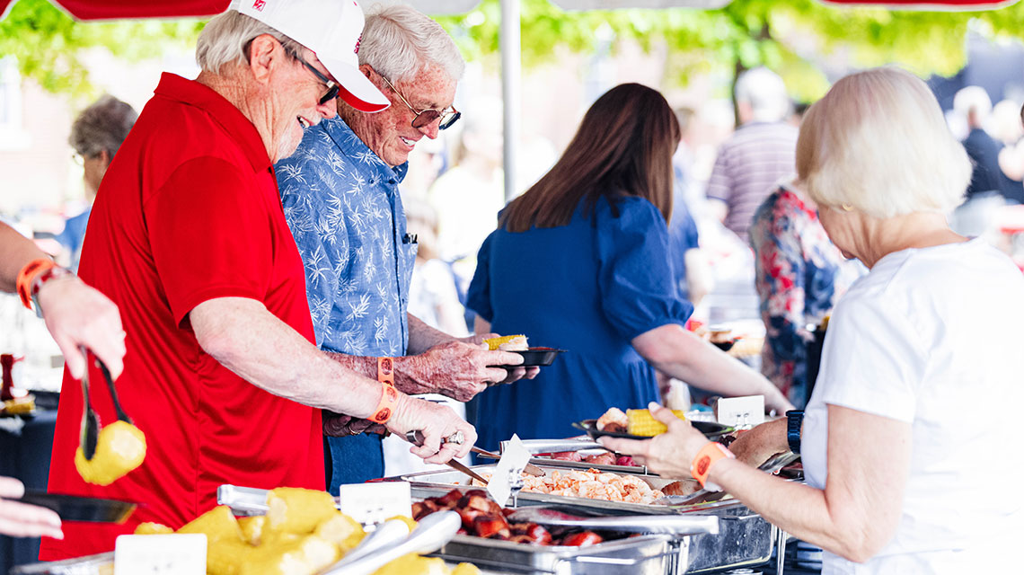 Alumni pile shrimp, corn, sausage, red potatoes, and garlic bread on their plates at the annual Alumni Shrimp Boil on campus. It’s a great opportunity to eat good food, visit with fellow Gamecocks, and listen to the music of the islands, performed by the university’s steel drum band.