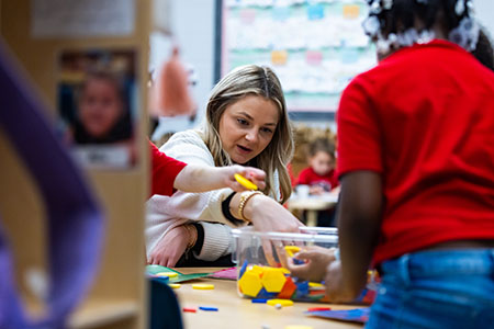 a teacher helps students learn to count at the cdc