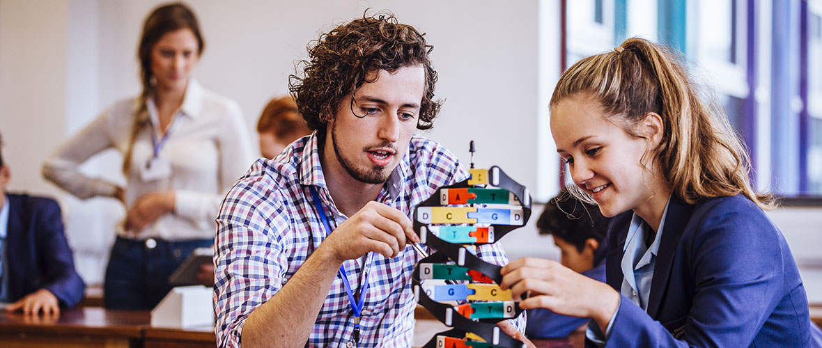 Science Instructor working with a student on a DNA model