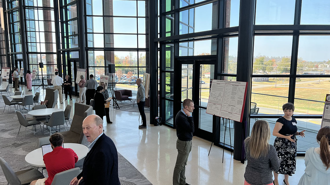 Attendees in the atrium of Merrill Hall