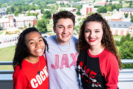 Students, wearing their Jax State gear, stand on the observation deck at Houston Cole Library, with the campus visible behind them