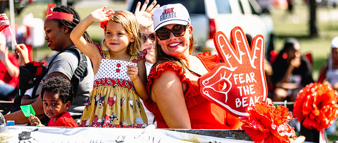 JSU alumni and their children ride on a "Growing Gamecocks" float in the 2023 Jax State Homecoming Parade.