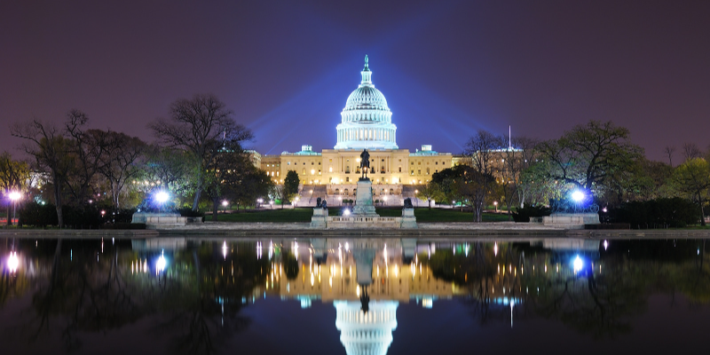 The US Capitol at night reflecting image over water.