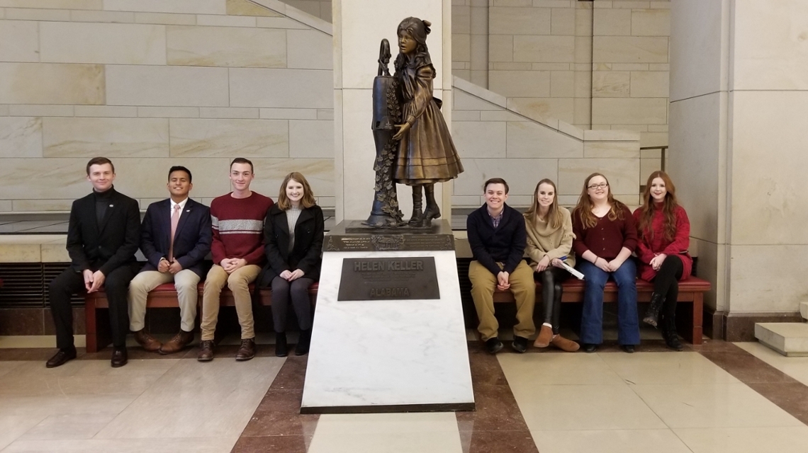 Students sitting by the Helen Keller Monument