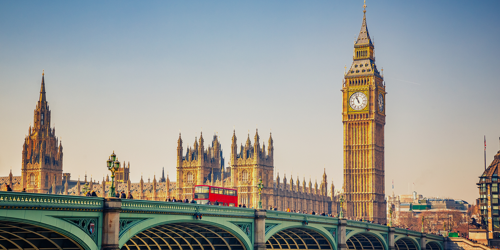 Photo of bridge in London, England with a red double-decker bus.