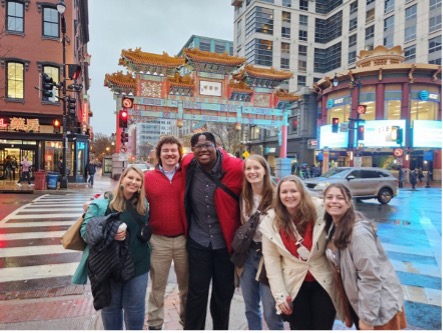 students in front of the colorful chinatown arch