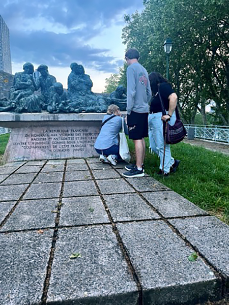 JSU students, including Honors student Maggie Saleeby (kneeling down), explore a monument of the Vel d’Hive in Paris, which they read about during the class.