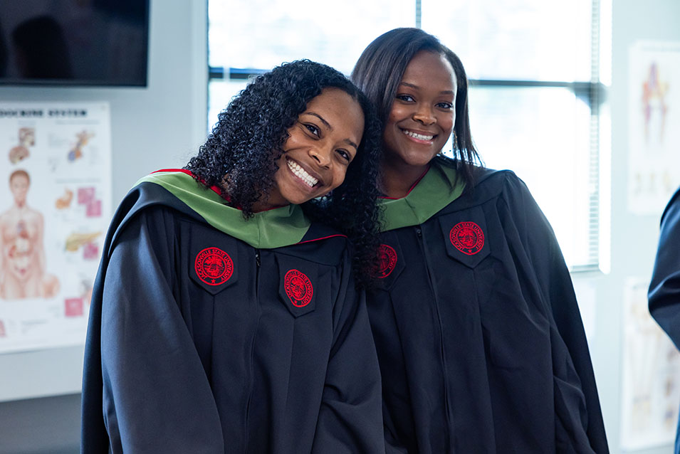 two graduate students before their graduation ceremony