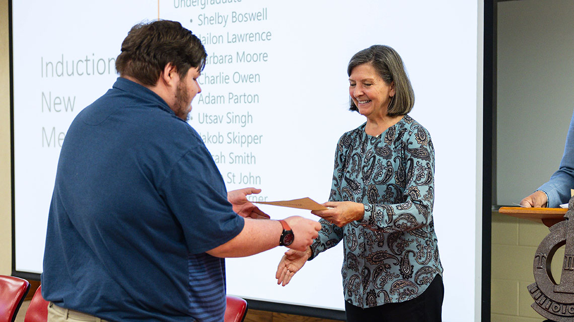 A student receives his certificate from Dr Case