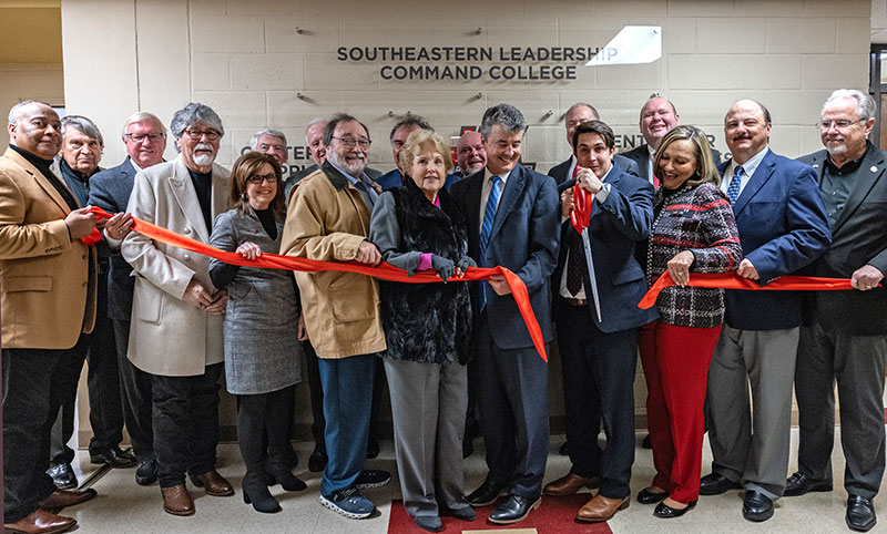 Trustees and state officials assist Kaleb Littlejohn in cutting the ribbon at the SLCC