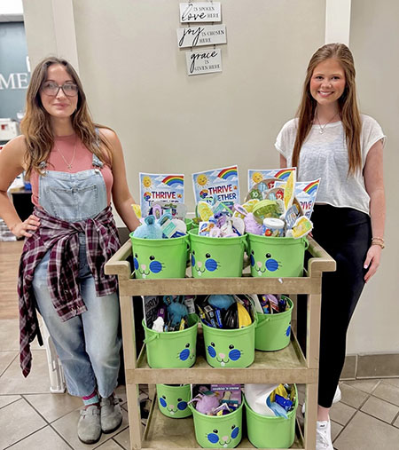 Aubree Ford stands next to Thrive Together display
