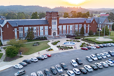 A full JSU parking lot, framed by trees displaying bright fall colors