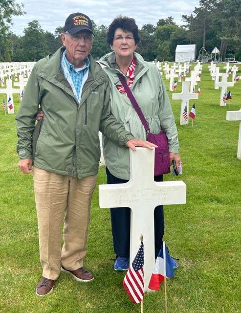 Will and Joan stand beside a relative's grave