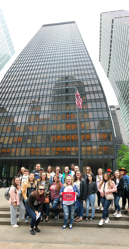 Doctor Mary Springer and study tour students in front of Seagram Building in New York