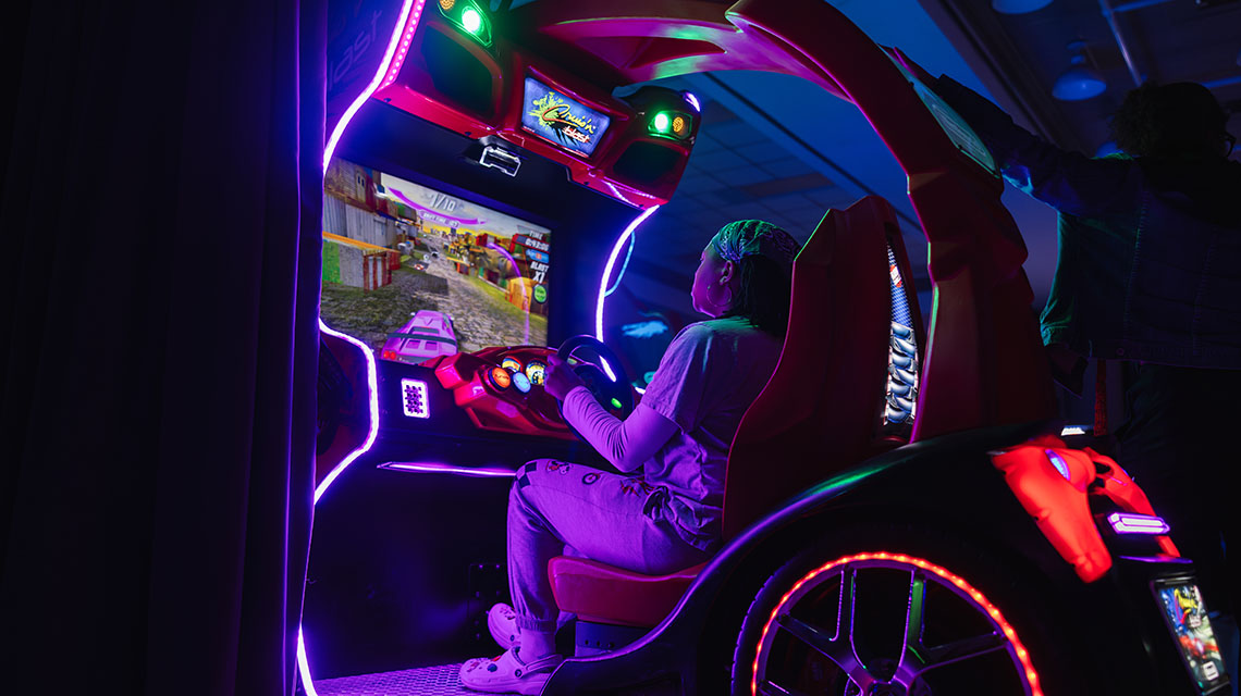 Student playing a racing arcade game
