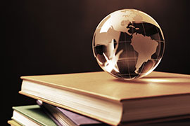 A crystal globe sits on top of a stack of books