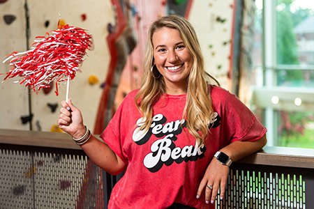 female student in a Fear the Beak shirt shaking a pompom